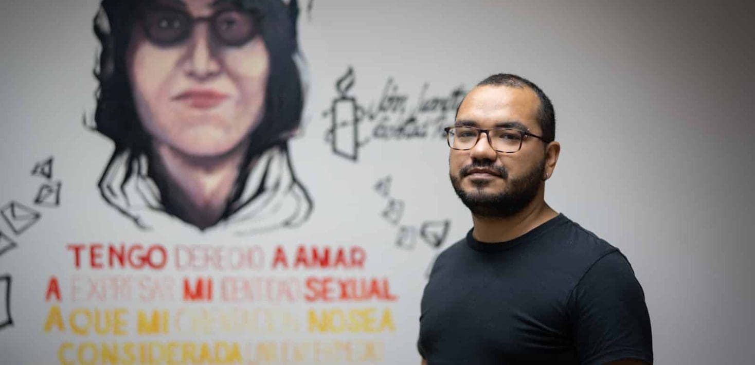 A man's face with a mural in background