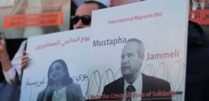 Protesters hold up signs showing pictures of civil society activists.