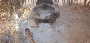 A clay pot sits on the ground, covered in dirt
