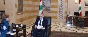 The Lebanese prime minister talks with Agnes Callamard in a large marble room. They are sitting in chairs.