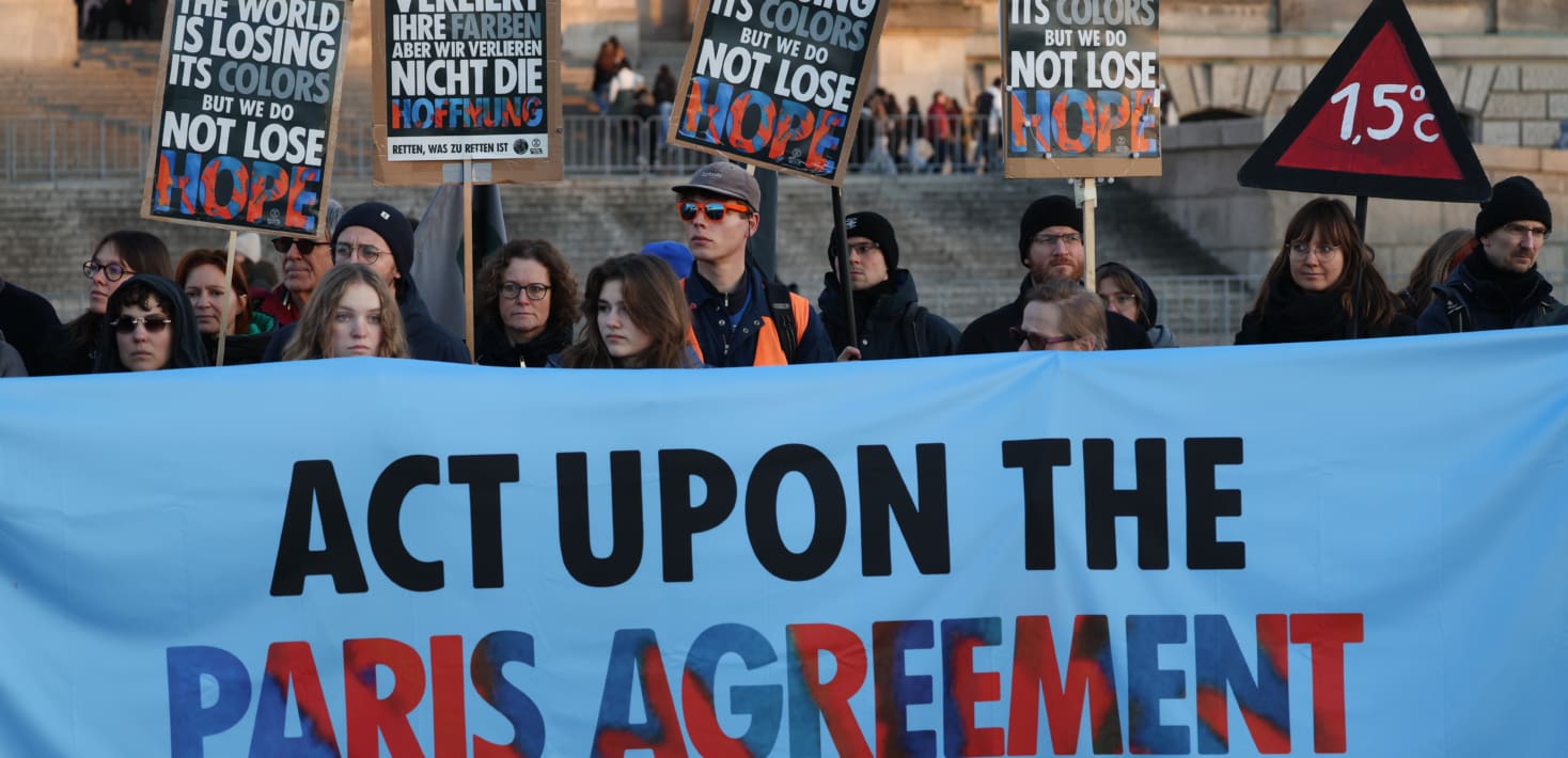 A group of young people holding a large protest banner that says 