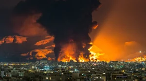bombed city with flames and smoke at night