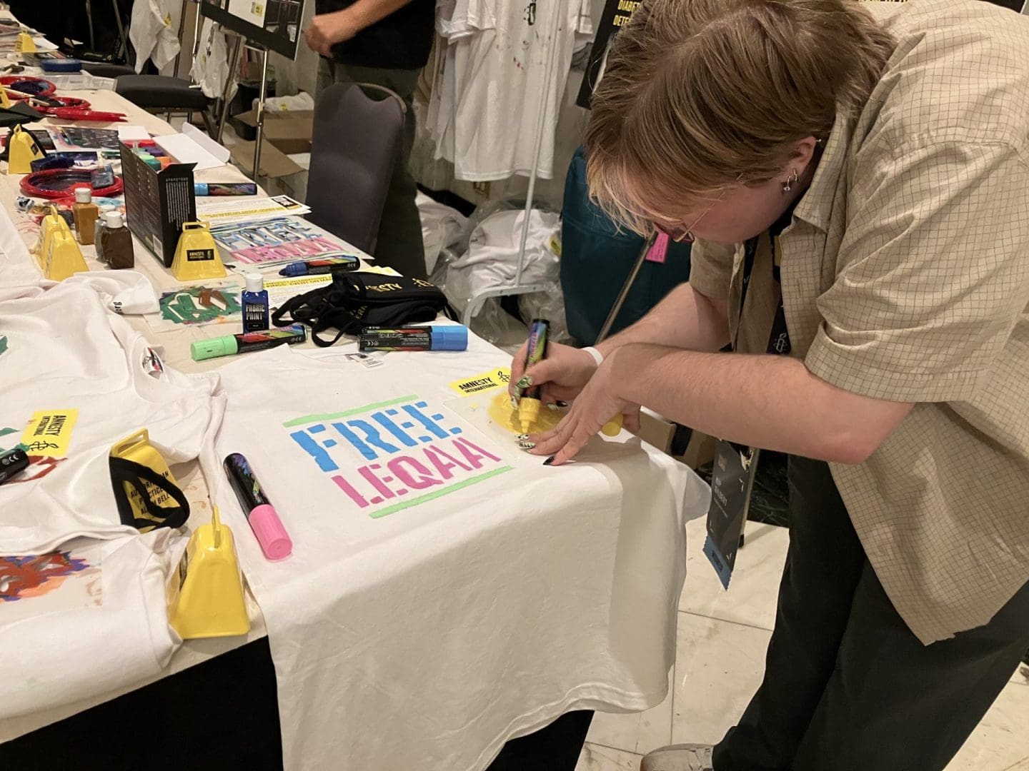 An Amnesty member makes a “Free Leqaa” shirt (Amnesty International USA)