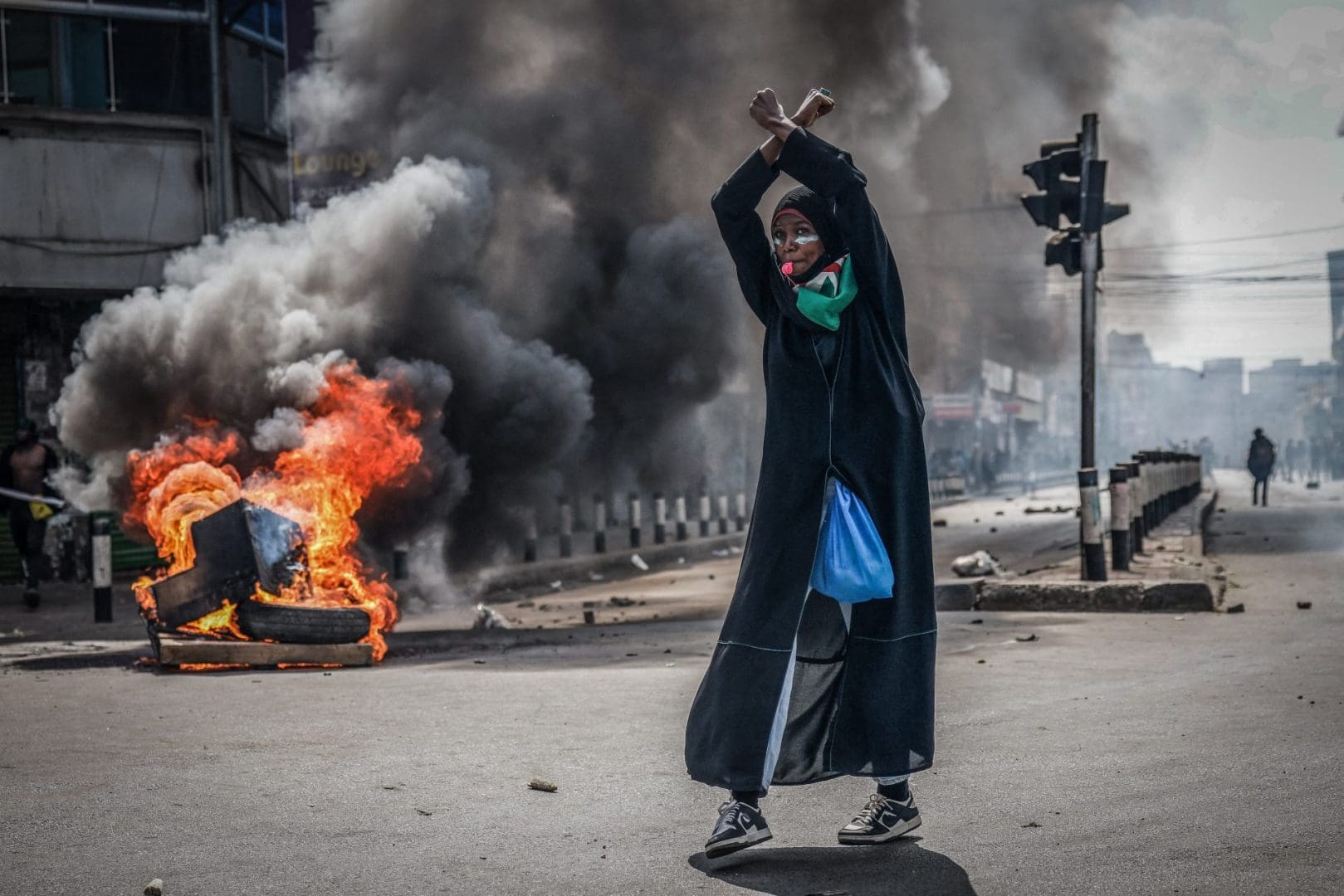 A protester reacts in front of a burning barricade in downtown Nairobi on June 25, 2025