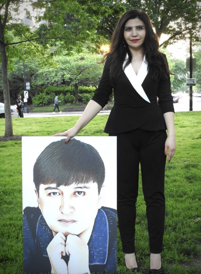 Rayhan Asat stands with a photo of her brother Ekpar Asat