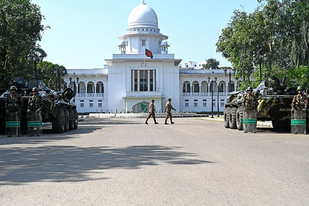 A domed white building with the Bangladesh flag flying above.