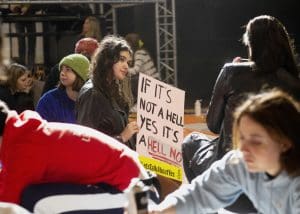 A woman holding a sign that says 