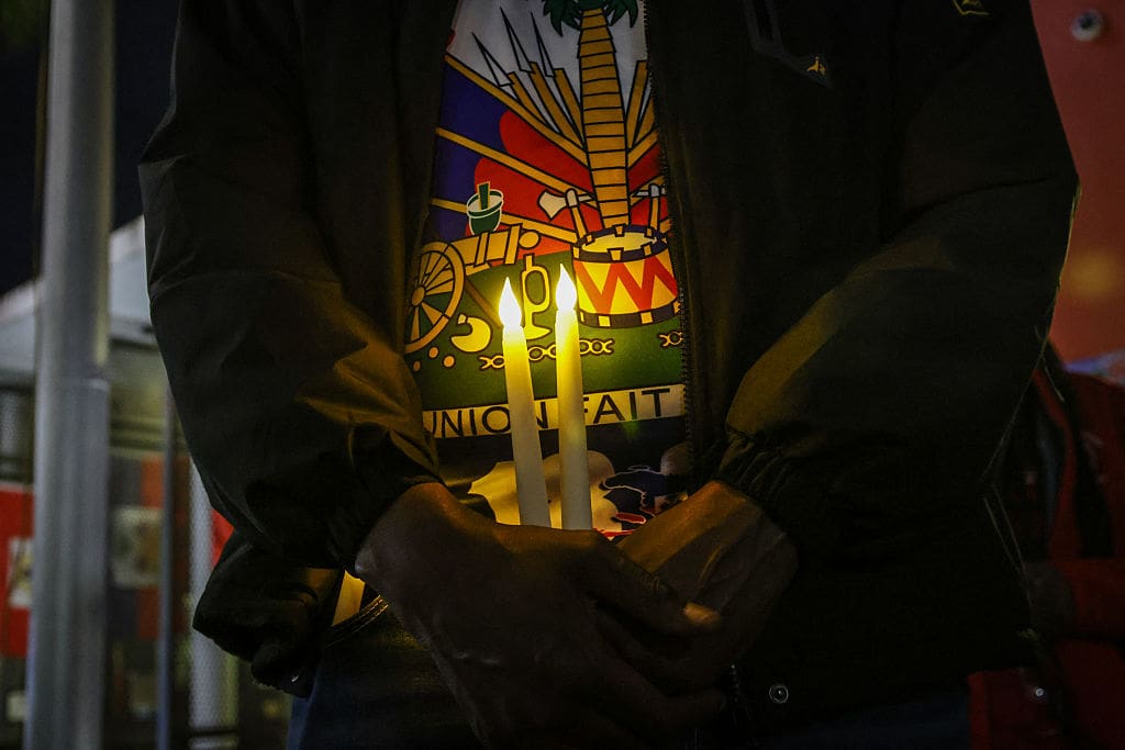 person holding candle advocating for TPS for Haiti