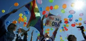 People release rainbow balloons in the sky.