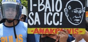 Protesters hold up a sign reading 