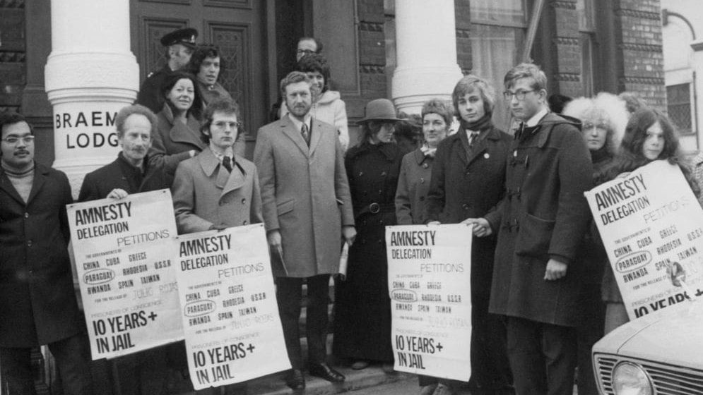 British journalist and author Anthony Grey leading a protest by members of the human rights organisation Amnesty International outside the Paraguayan embassy in London, 20th November 1971.