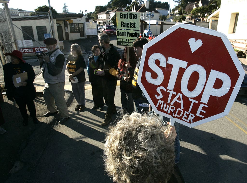 Anti-death penalty advocates protest outside gates of San Quentin while awaiting word on the fate of death row inmate Stanley Tookie Williams.