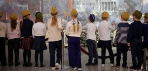 A group of schoolchildren facing their back to the camera.