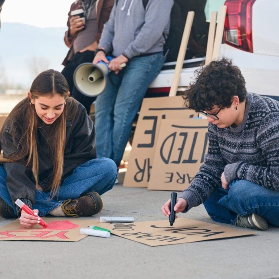 Group of people talking and preparing materials together during a community project outdoors