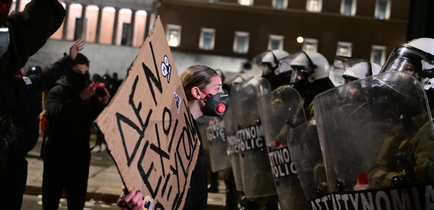 Woman protester face-to-face with several riot police.