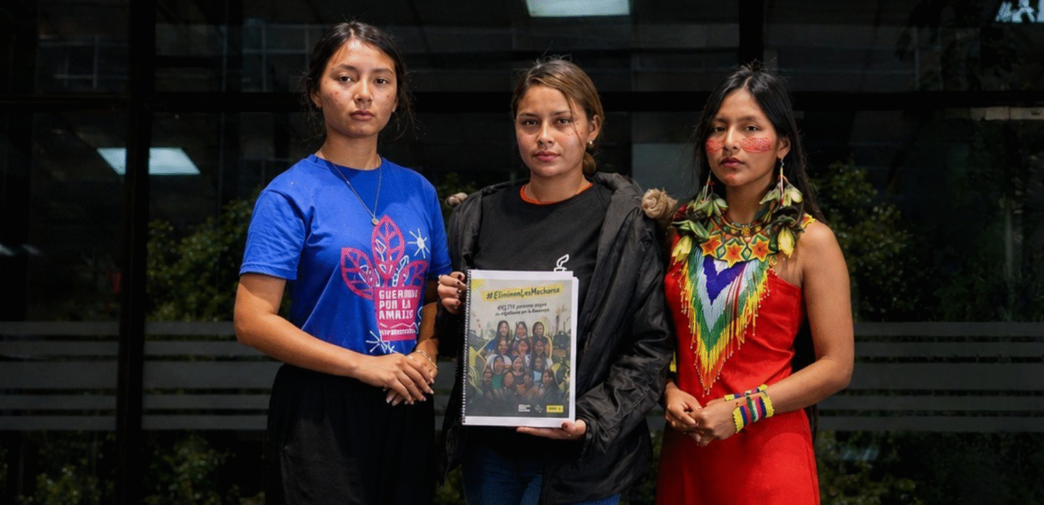 three Ecuadorian women holding a sign
