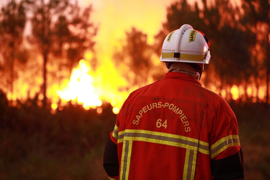 A firefighter facing a wildfire.