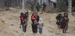 Women holding their children and walking.