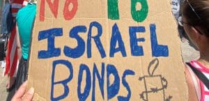 Protester holds up placard that says 'No To Israel Bonds'