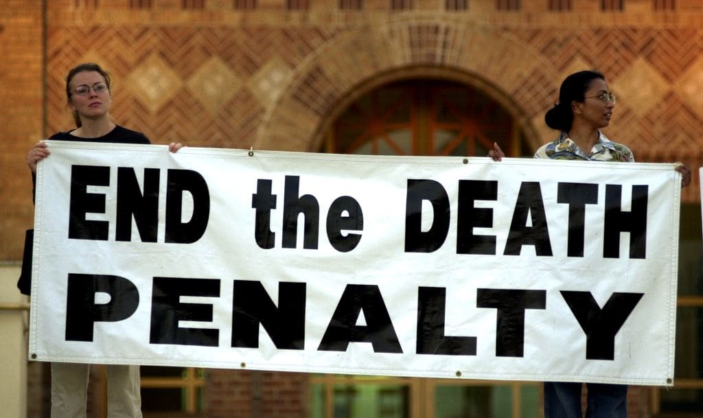 protestors hold a banner that reads 