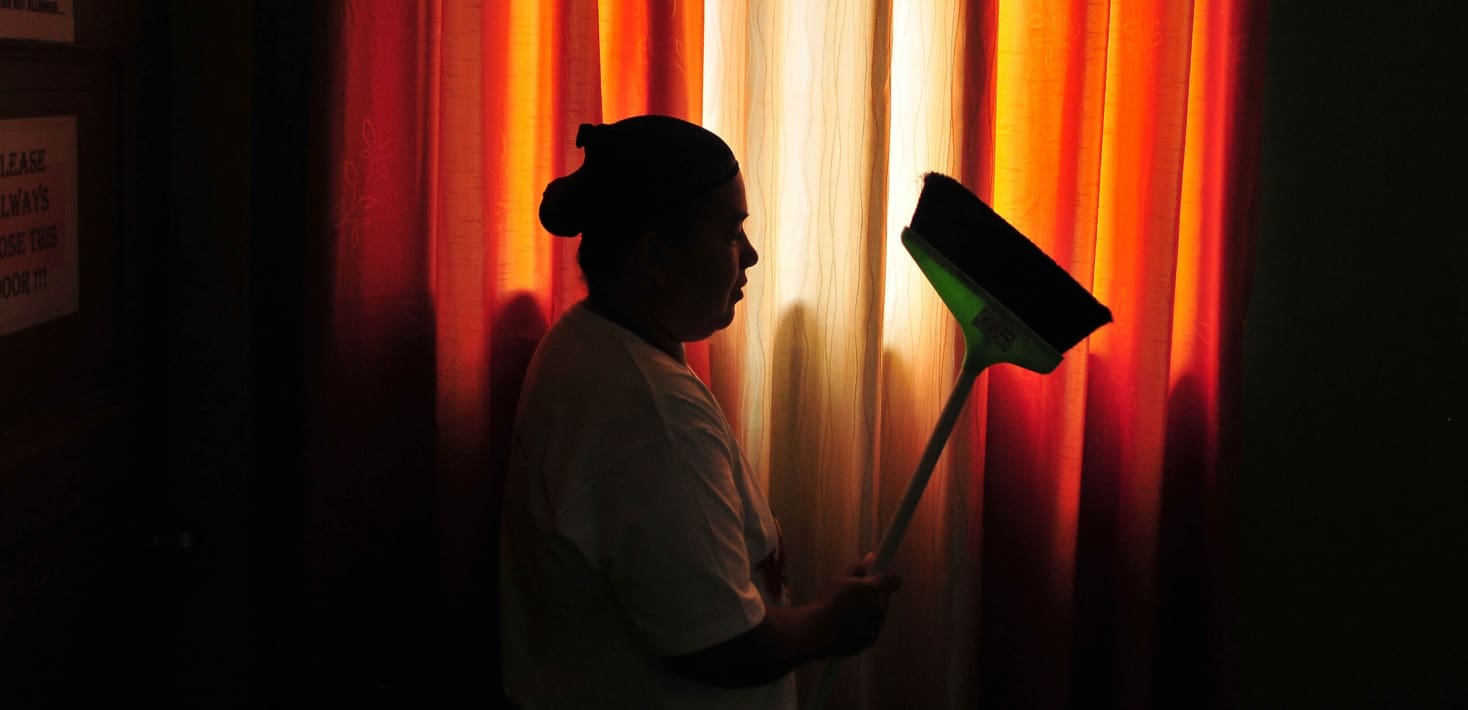 A silhouette of a woman with a broom.