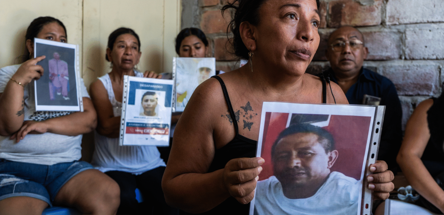 Ecuadorians holding photos of lost loved ones