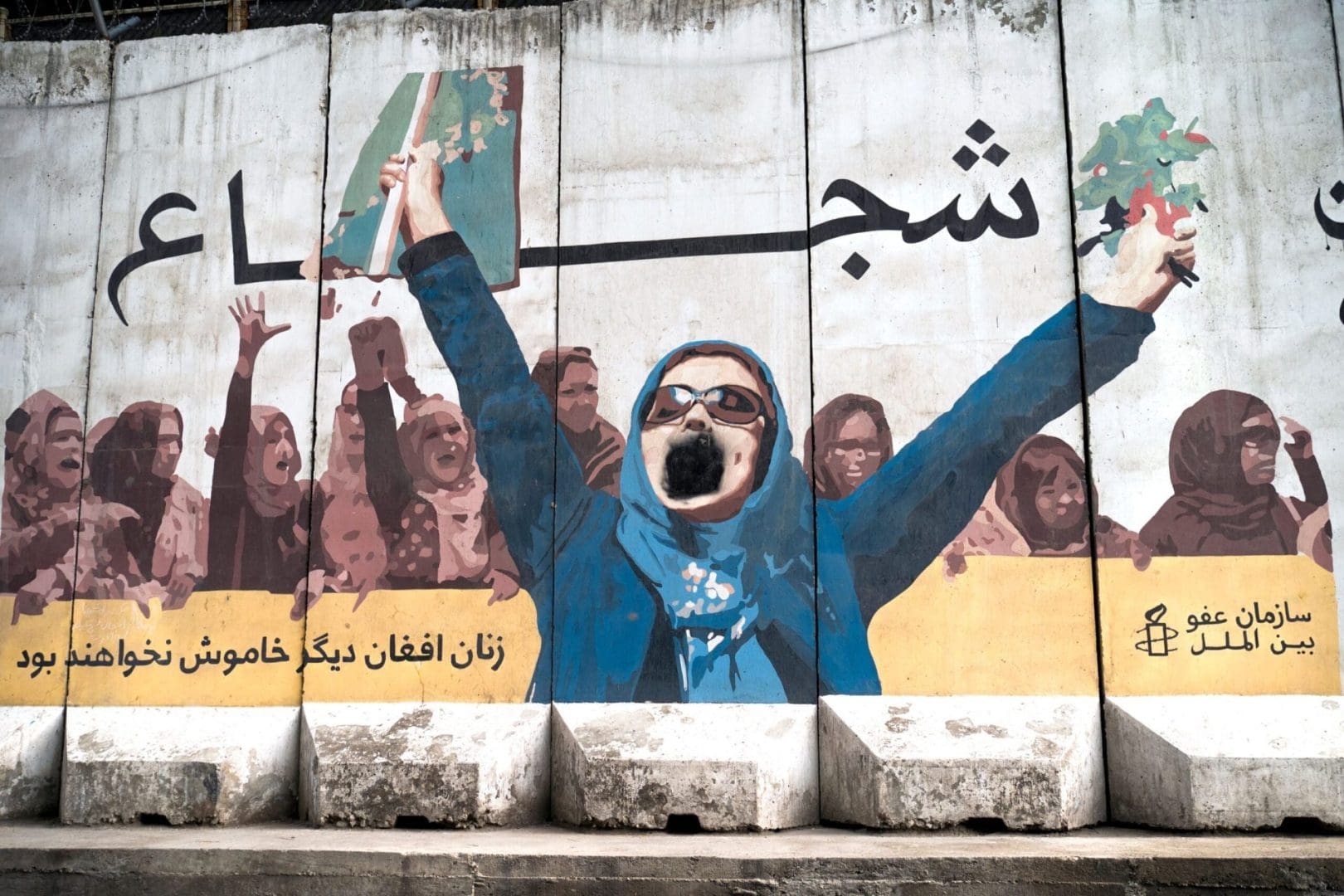 graffiti on Afghanistan wall of woman with outstretched arms and screaming