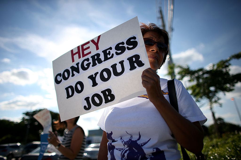 woman holds a sign reading, 