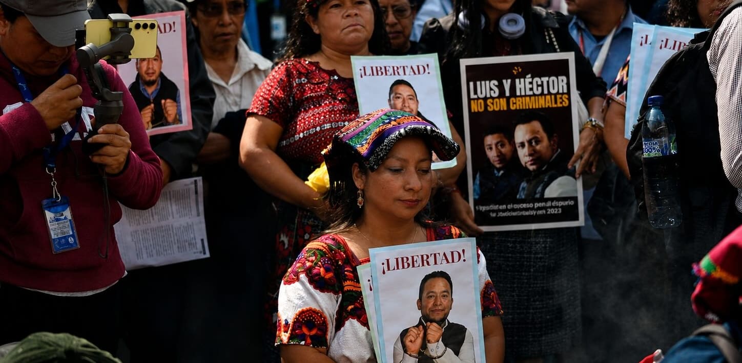 people holding signs in support of Luis Pacheco and Héctor Chaclán