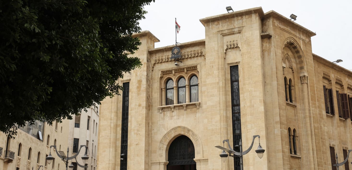 An old official looking building with a small Lebanese flag on top.