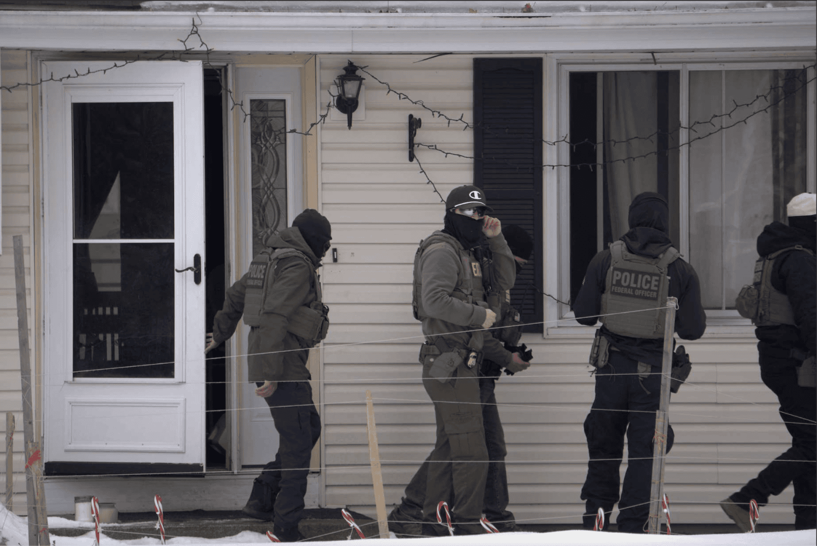 ICE agents outside a house.