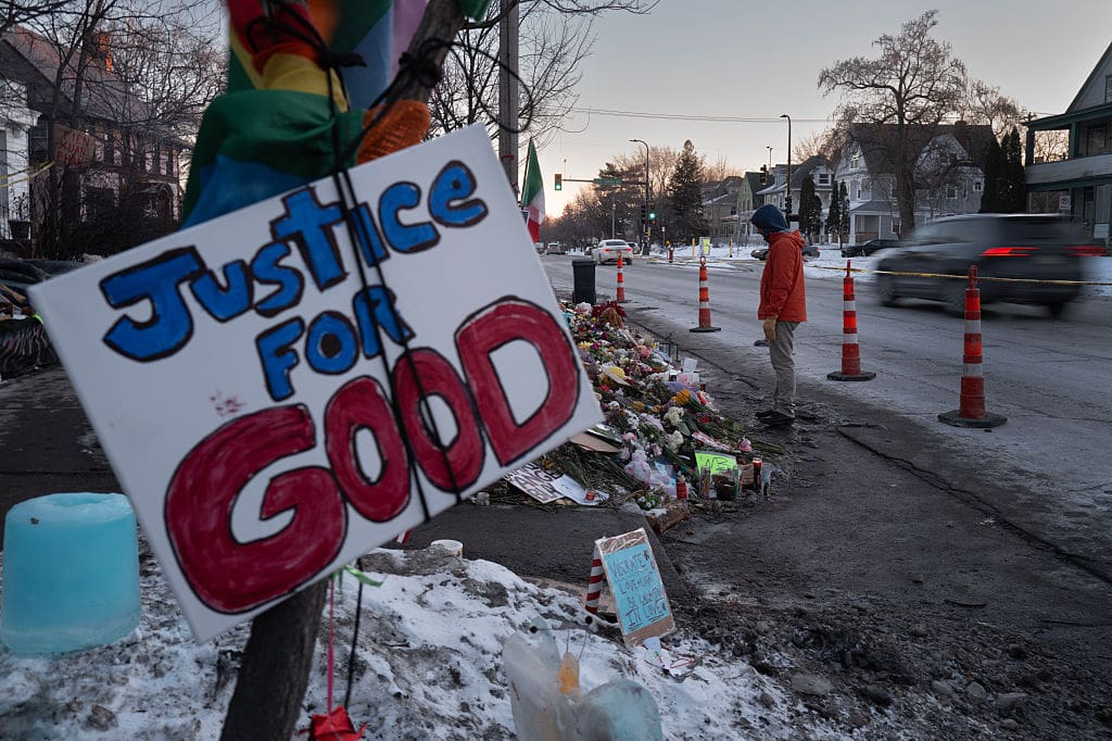 People visit a memorial to Renee Good on January 29, 2026 in Minneapolis, Minnesota in front of a sign that reads "Justice for GOod"