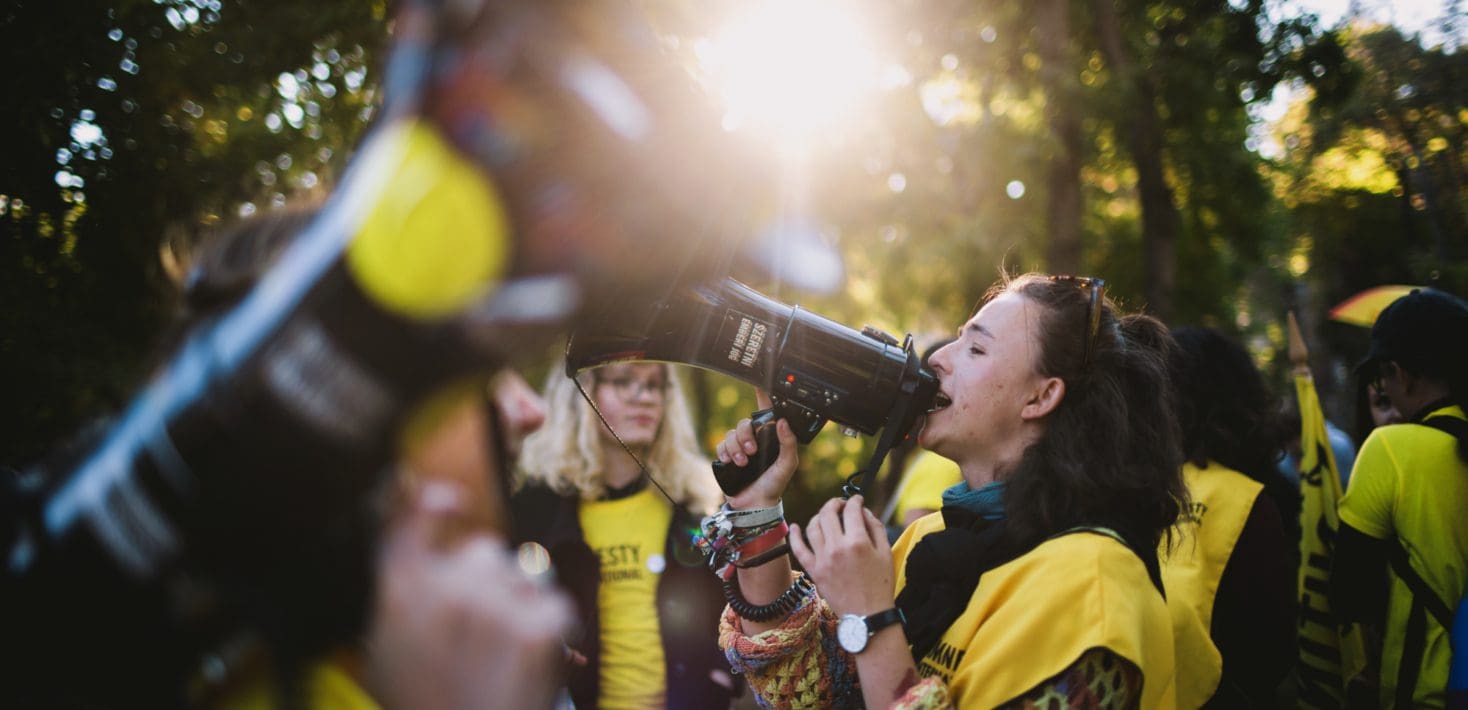 A woman yelling into a megaphone during a protest.
