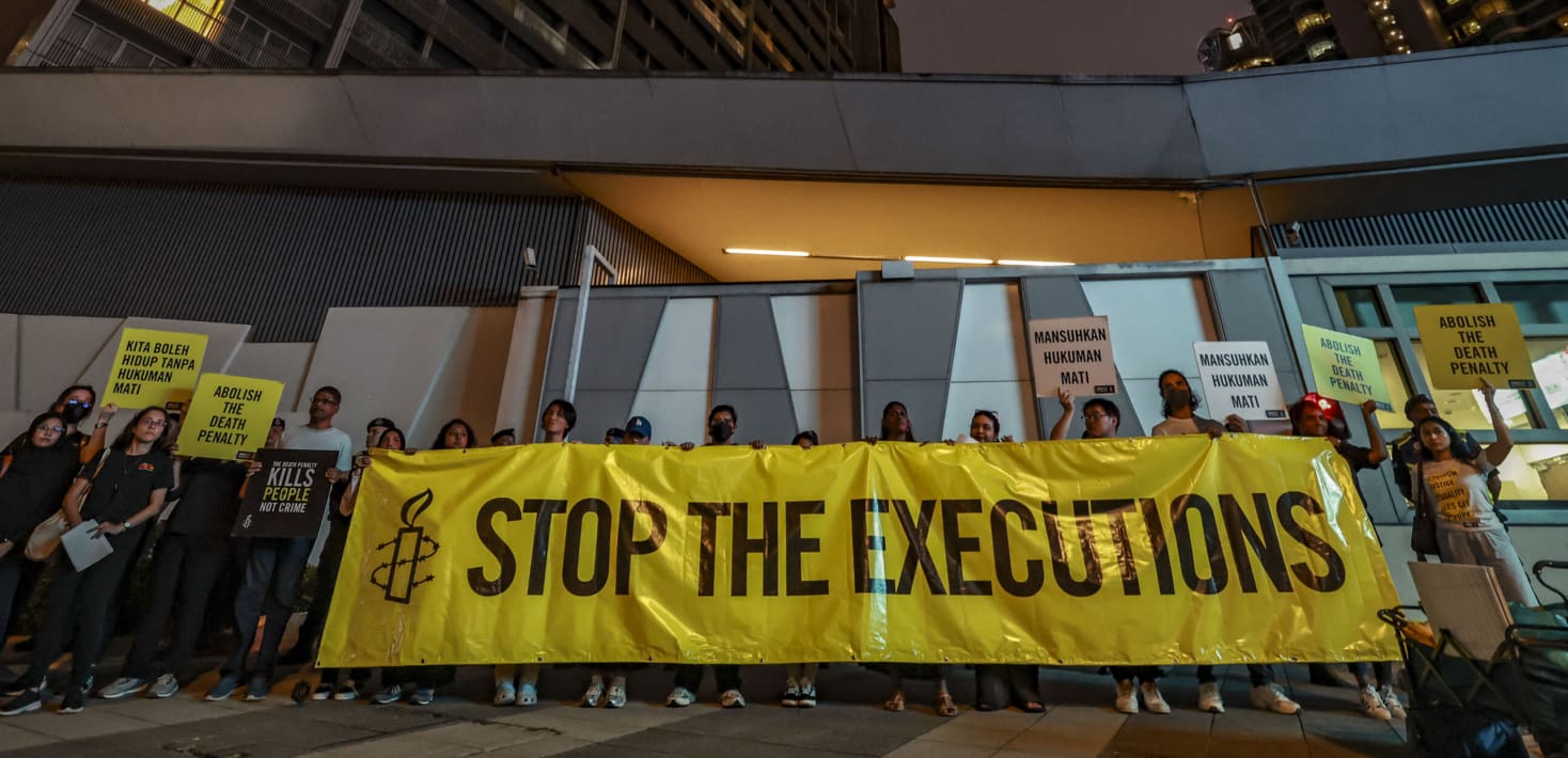 Amnesty International sign in yellow that says Stop the Executions