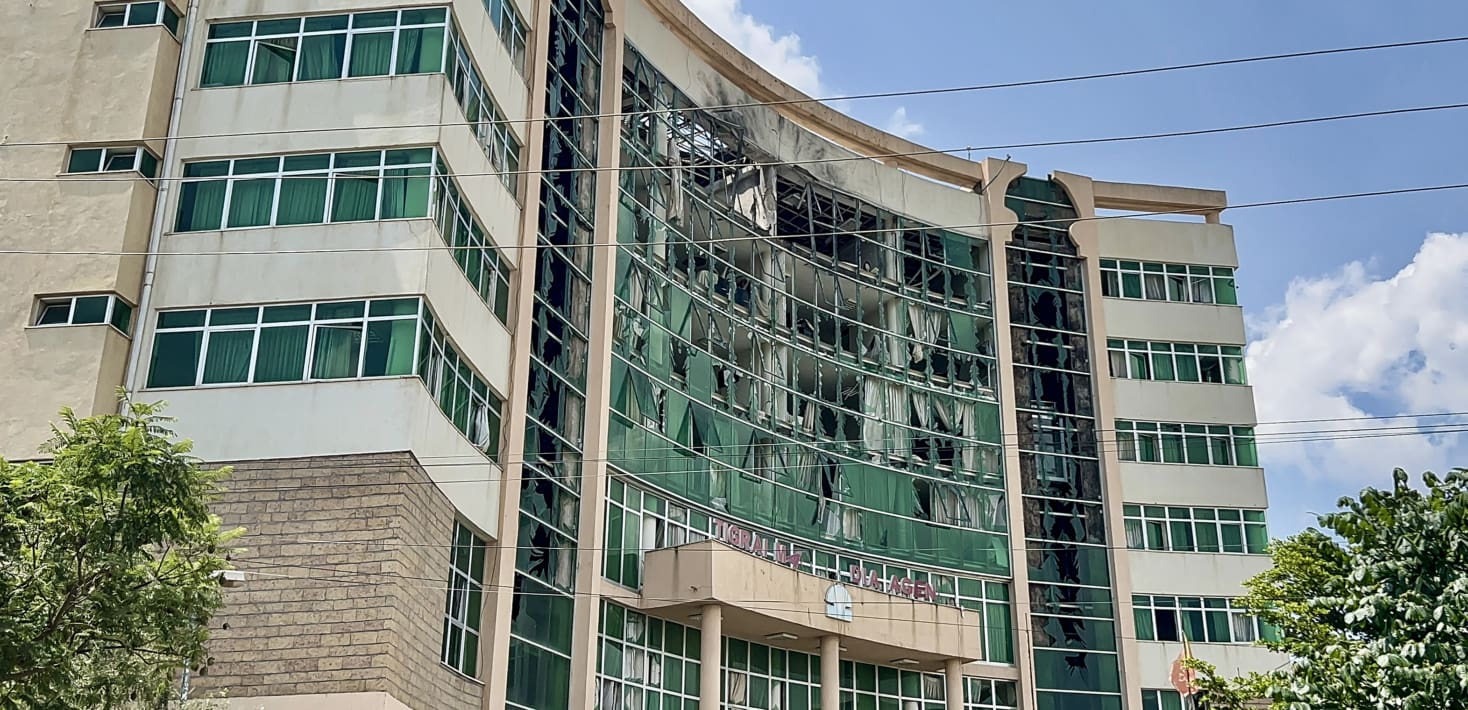A building with shattered windows and some burn marks.