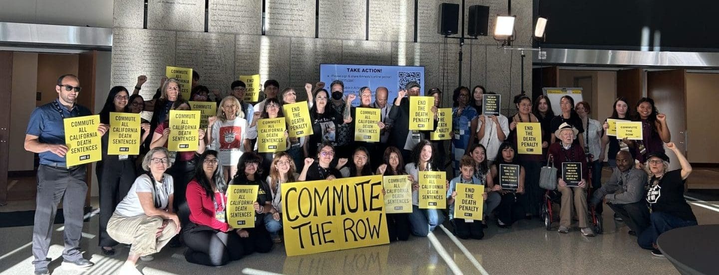Amnesty International USA activists hold signs that read Commute the Row, End the Death Penalty and Commute all death sentences in CA