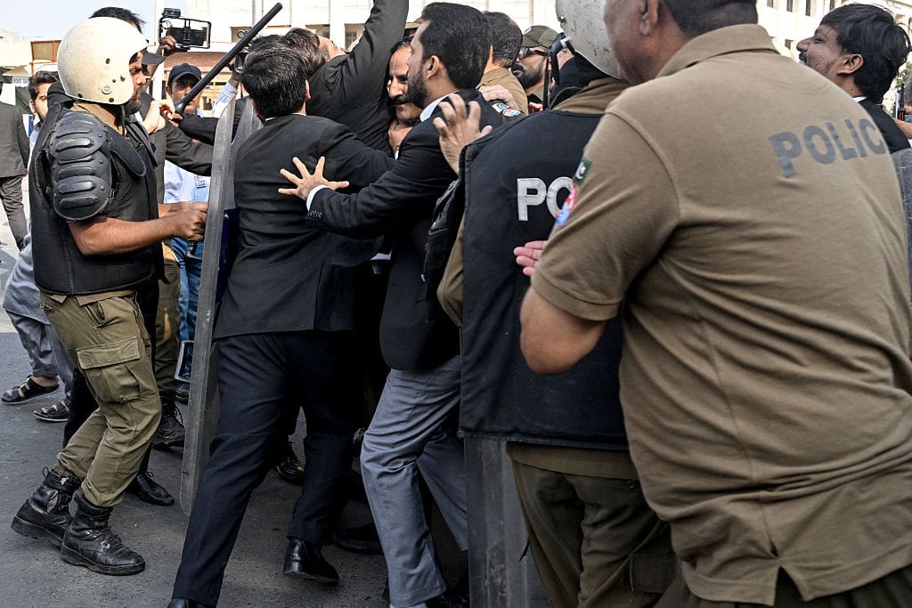 Struggle between police with shields/batons and civilians.