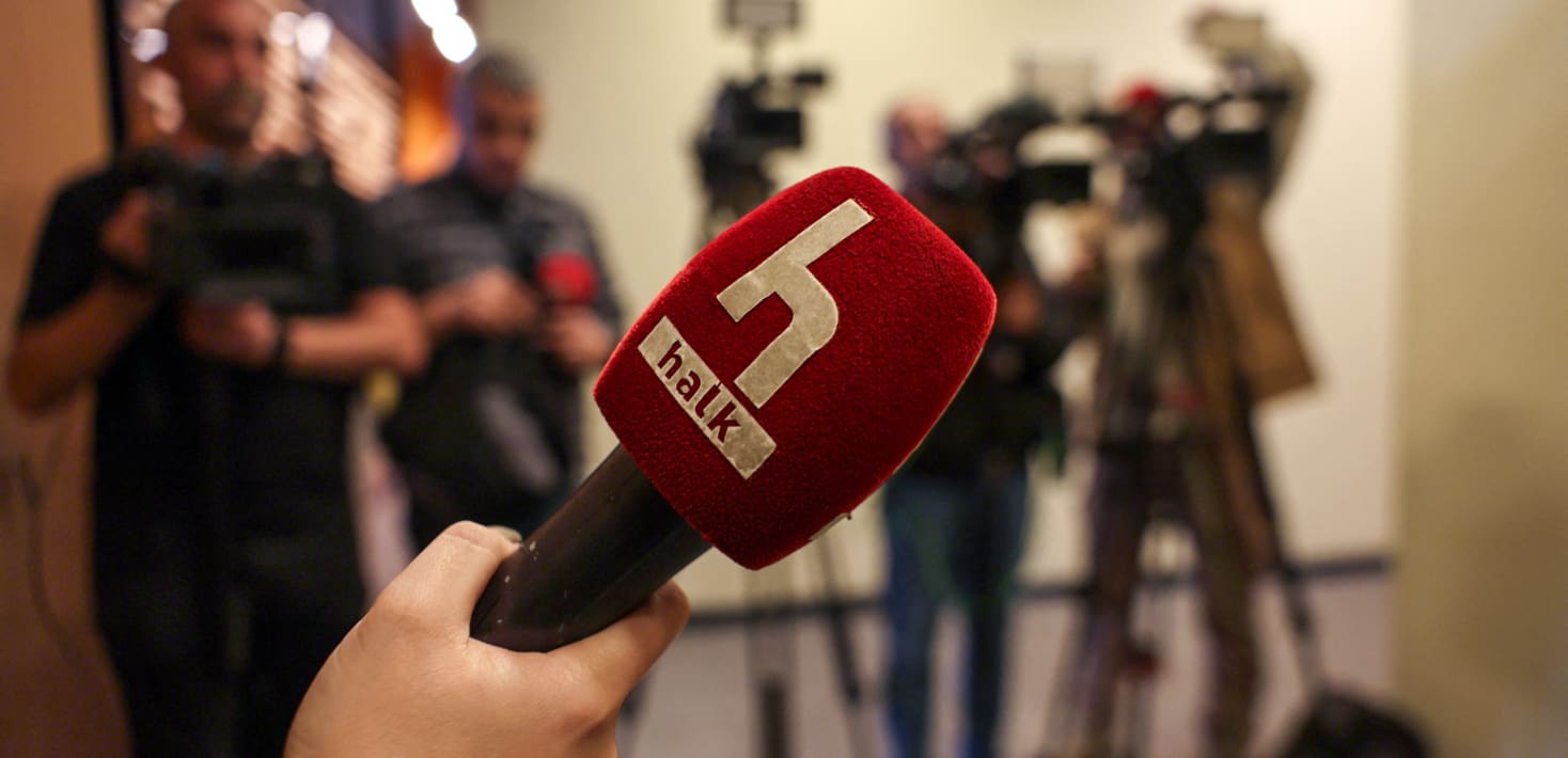 A close-up of a red press microphone that says 